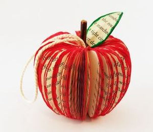 Handmade apple book ornament resting on table